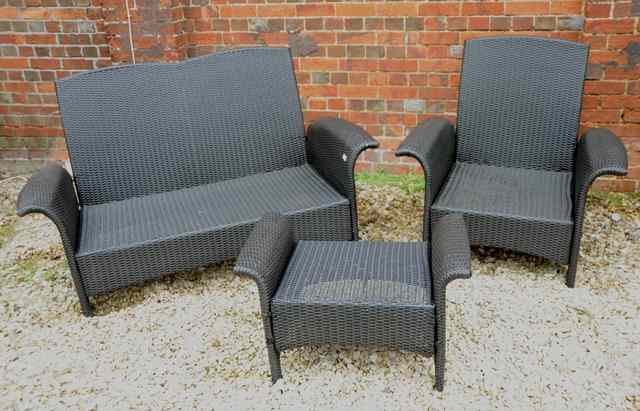 Appraisal: A BLACK RATTAN STYLE GARDEN SOFA approximately wide together with