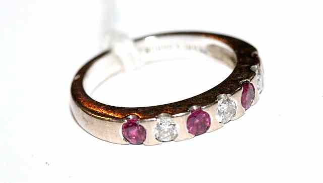 Appraisal: A SEVEN STONE RUBY AND DIAMOND RING alternately set four