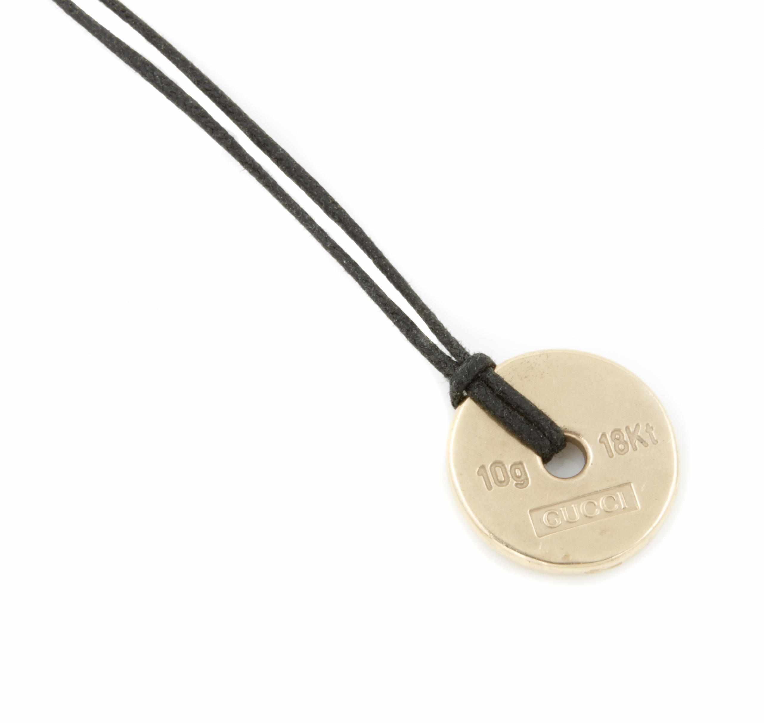 Appraisal: An K gold pendant with a black chord Gucci signed