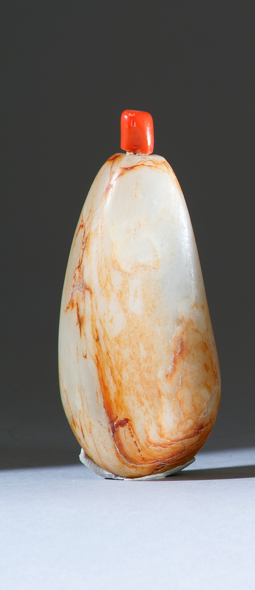 Appraisal: WHITE AND RUSSET JADE SNUFF BOTTLE th CenturyIn pebble form