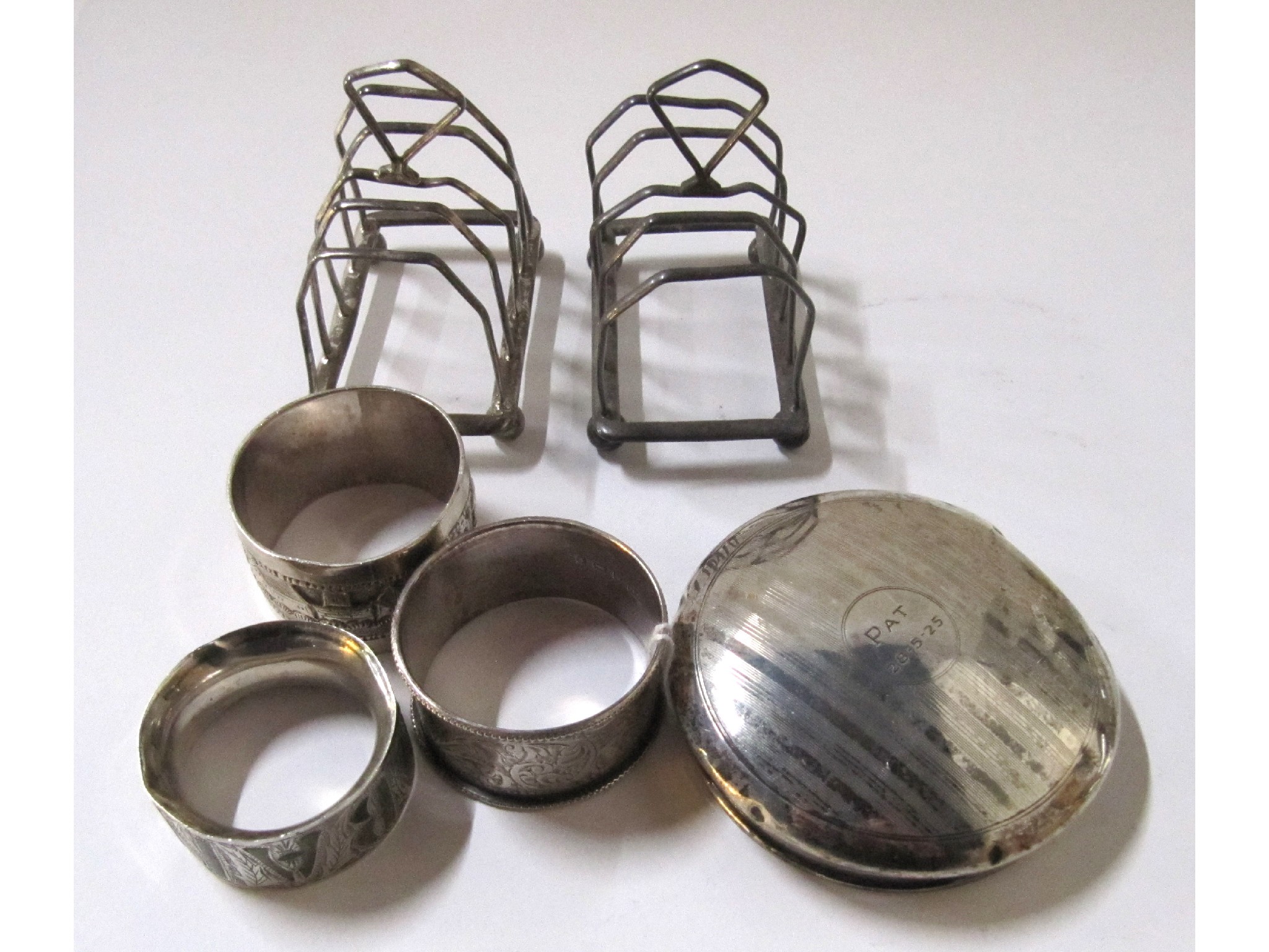 Appraisal: A lot comprising two silver toastracks three napkin rings and