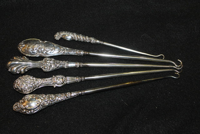 Appraisal: A COLLECTION OF FIVE VARIOUS VICTORIAN SILVER HANDLED BUTTON HOOKS