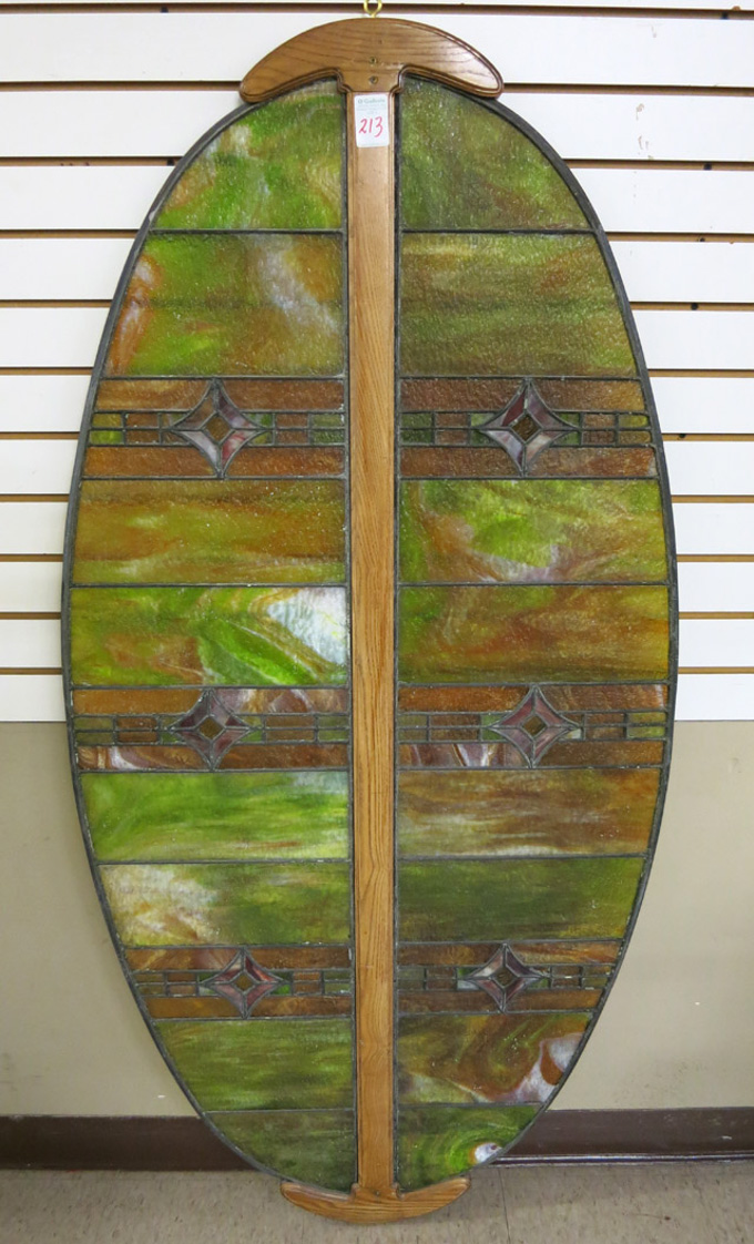 Appraisal: AN OVAL STAINED AND LEADED GLASS WINDOW PANEL featuring two