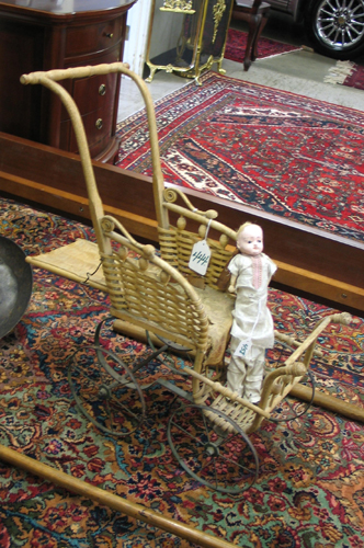 Appraisal: A CHILD'S DOLL BUGGY with bent wood handle supports woven