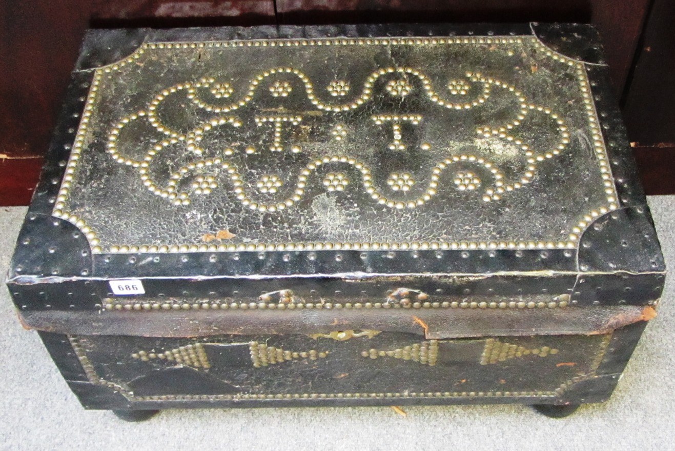 Appraisal: An English leather and brass studded trunk with side carrying