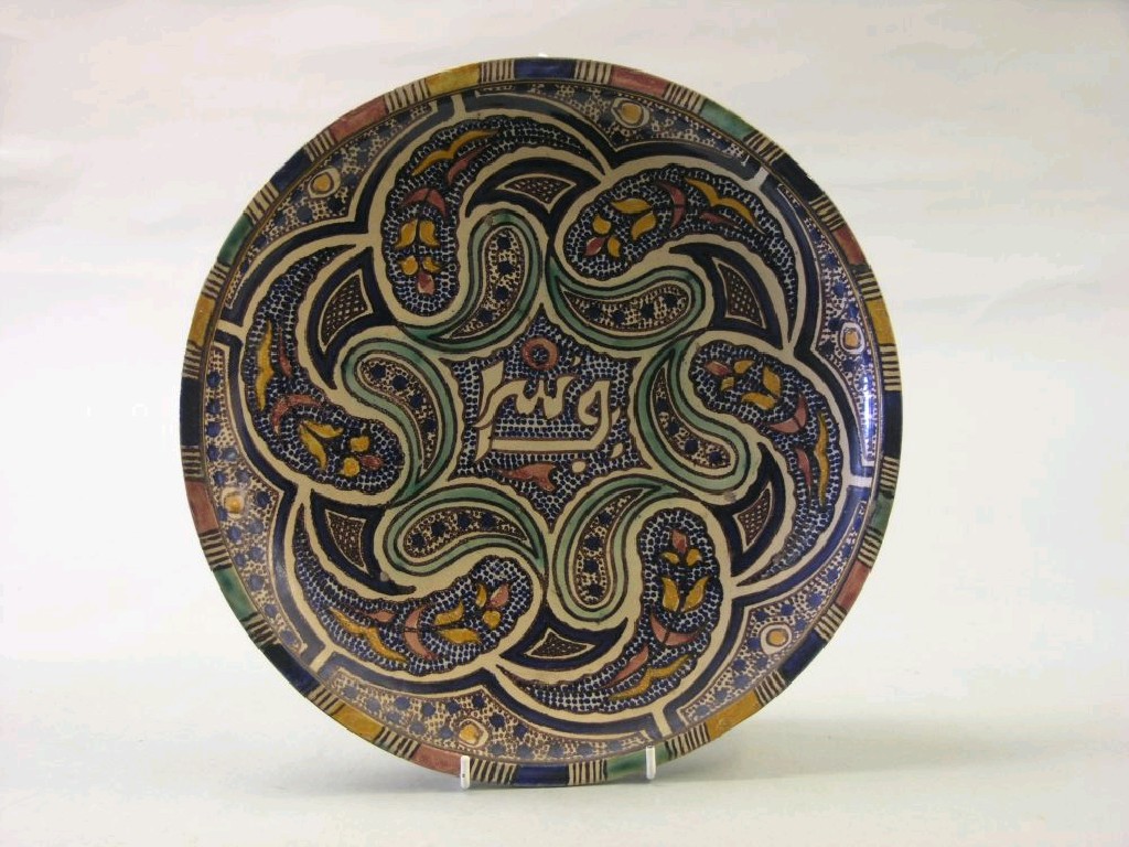 Appraisal: A Persian charger painted with a stylised floral design in