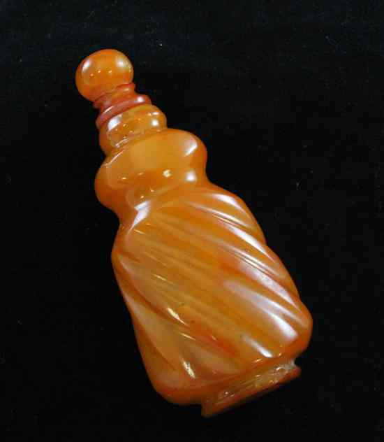 Appraisal: A Chinese amber spiral fluted snuff bottle and stopper ins