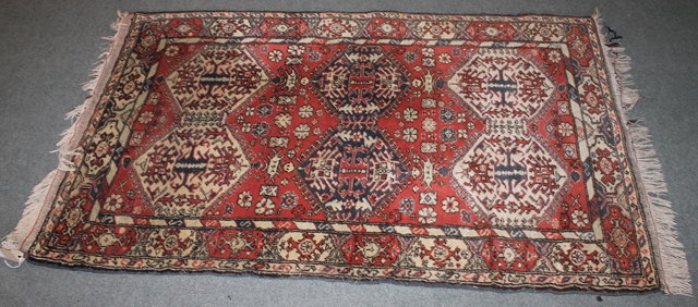 Appraisal: A WOOL PAKISTAN RED GROUND RUG with six medallions cm