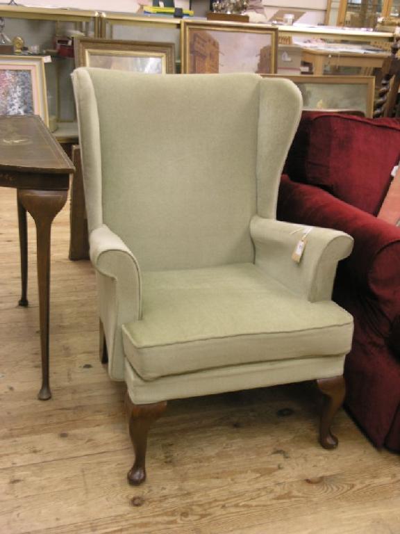 Appraisal: A wing armchair upholstered in a pale green dralon on