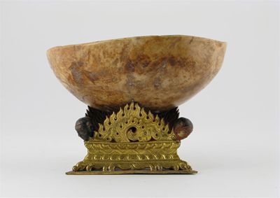 Appraisal: A Tibetan skull bowl or kapala standing on a triform