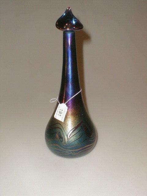 Appraisal: An iridescent bottle vase with pulled lip feathered swirls around