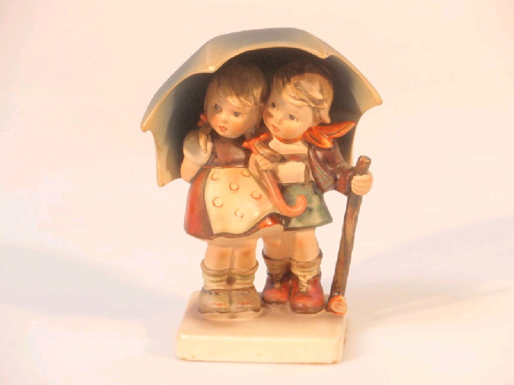 Appraisal: A Hummel figure group of boy and girl under an