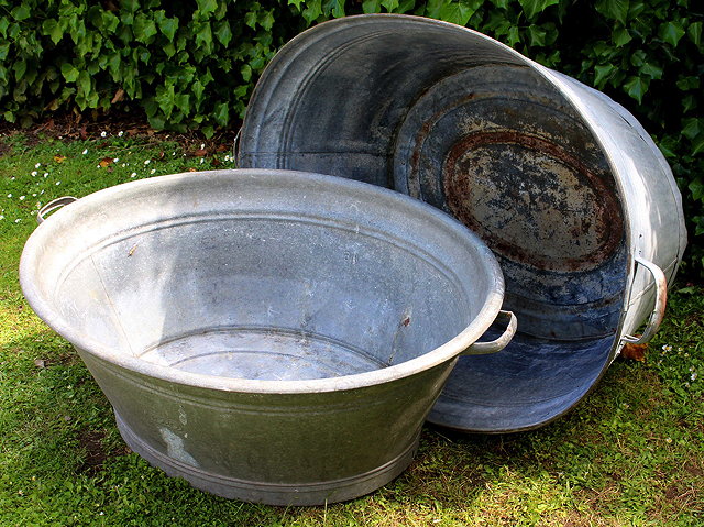 Appraisal: TWO OVAL GALVANISED BATHS with carrying handles the largest cm