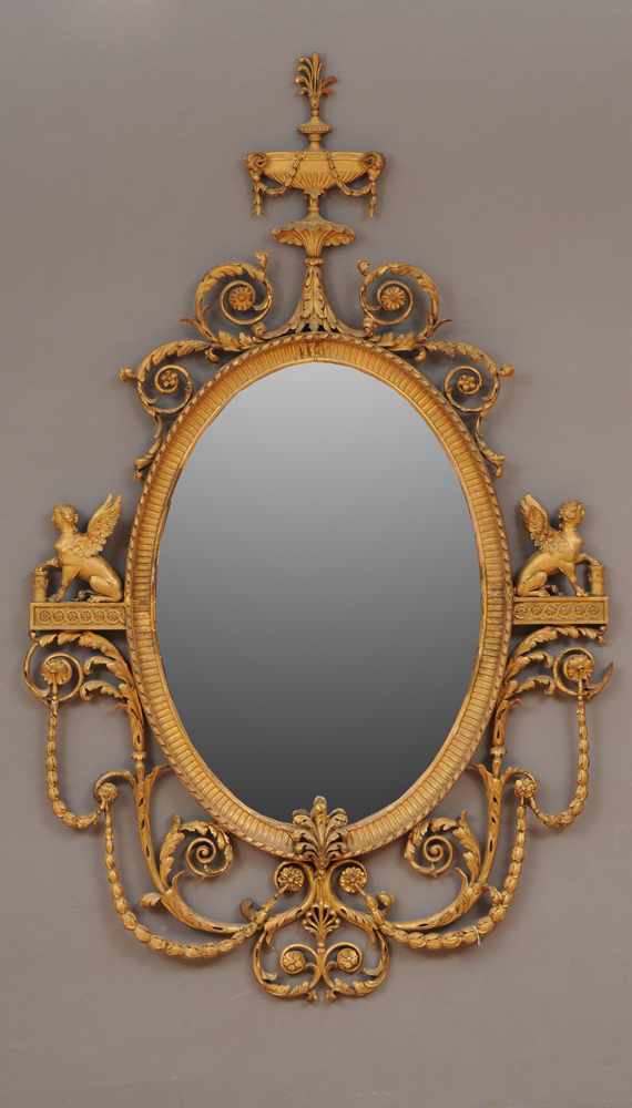 Appraisal: GEORGE III STYLE CARVED GILTWOOD OVAL PIER MIRROR The fluted