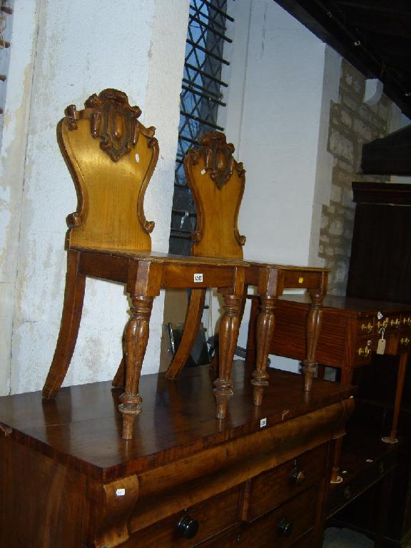 Appraisal: A pair of Victorian oak hall chairs with shield shaped