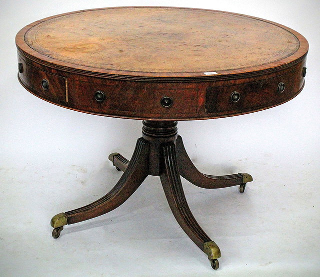 Appraisal: A LIBRARY DRUM TABLE with a tan leather inset top