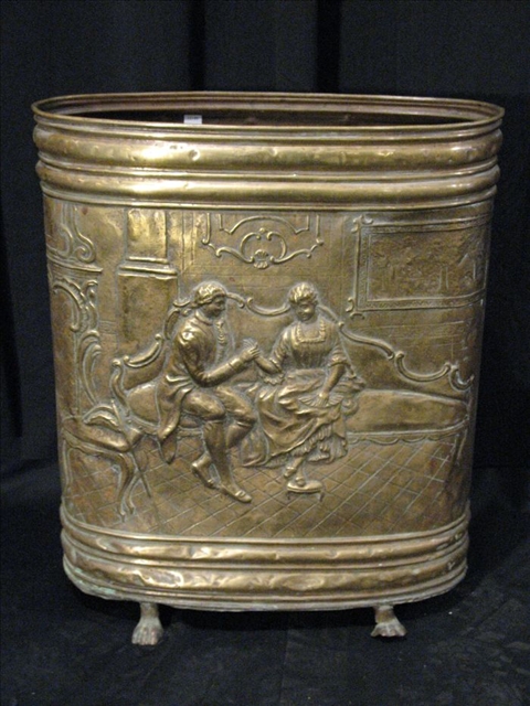 Appraisal: BRASS EMBOSSED OVAL UMBRELLA STAND Depicting an interior scene h