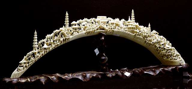 Appraisal: A Chinese ivory bridge carved with village scenes houses and