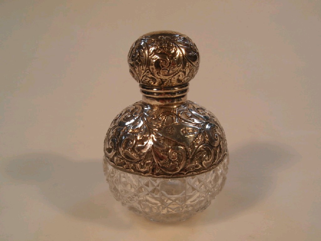 Appraisal: Edwardian spherical scent bottle with facet cut body and silver