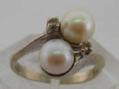 Appraisal: A cultured pearl cross over ring the two pearls mm