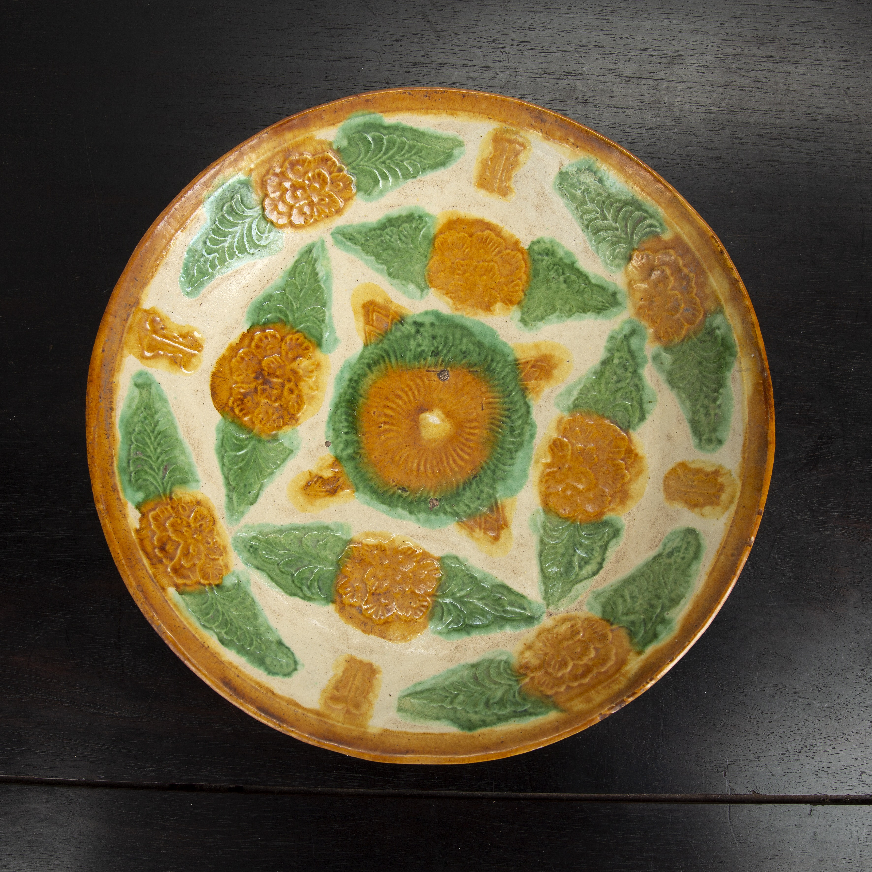 Appraisal: Sancai glazed plate Chinese the centre is decorated with applied