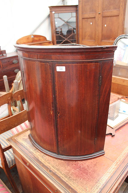 Appraisal: A GEORGE III BOW FRONTED MAHOGANY HANGING CORNER CABINET of