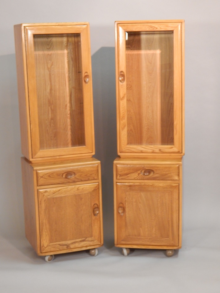 Appraisal: A pair of Ercol light elm narrow display cabinets each