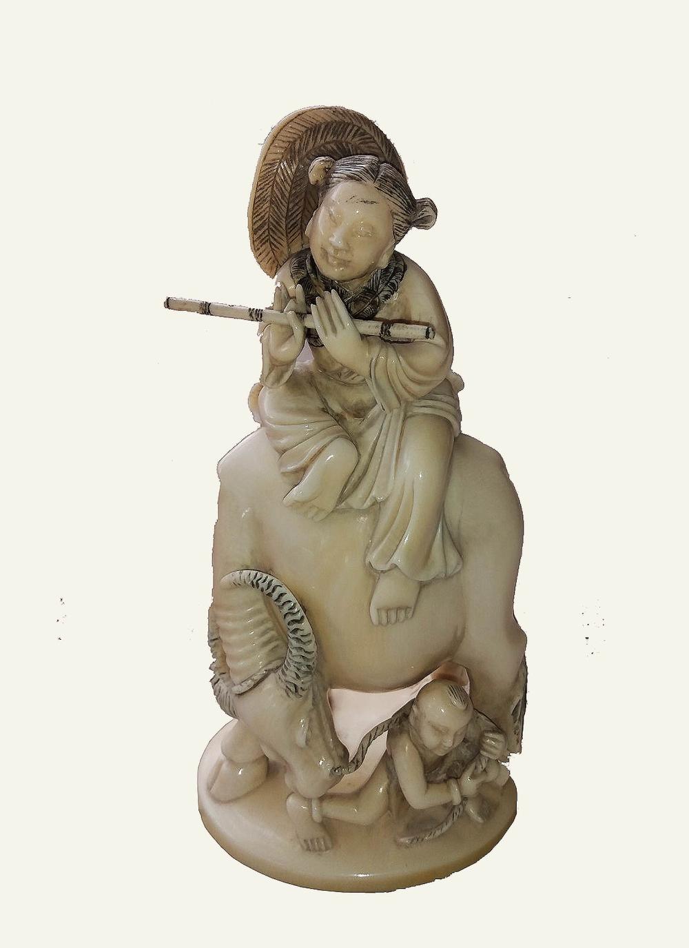 Appraisal: CHINESE CARVED FIGURE OF A MAIDEN ATOP AN OXENThe underside