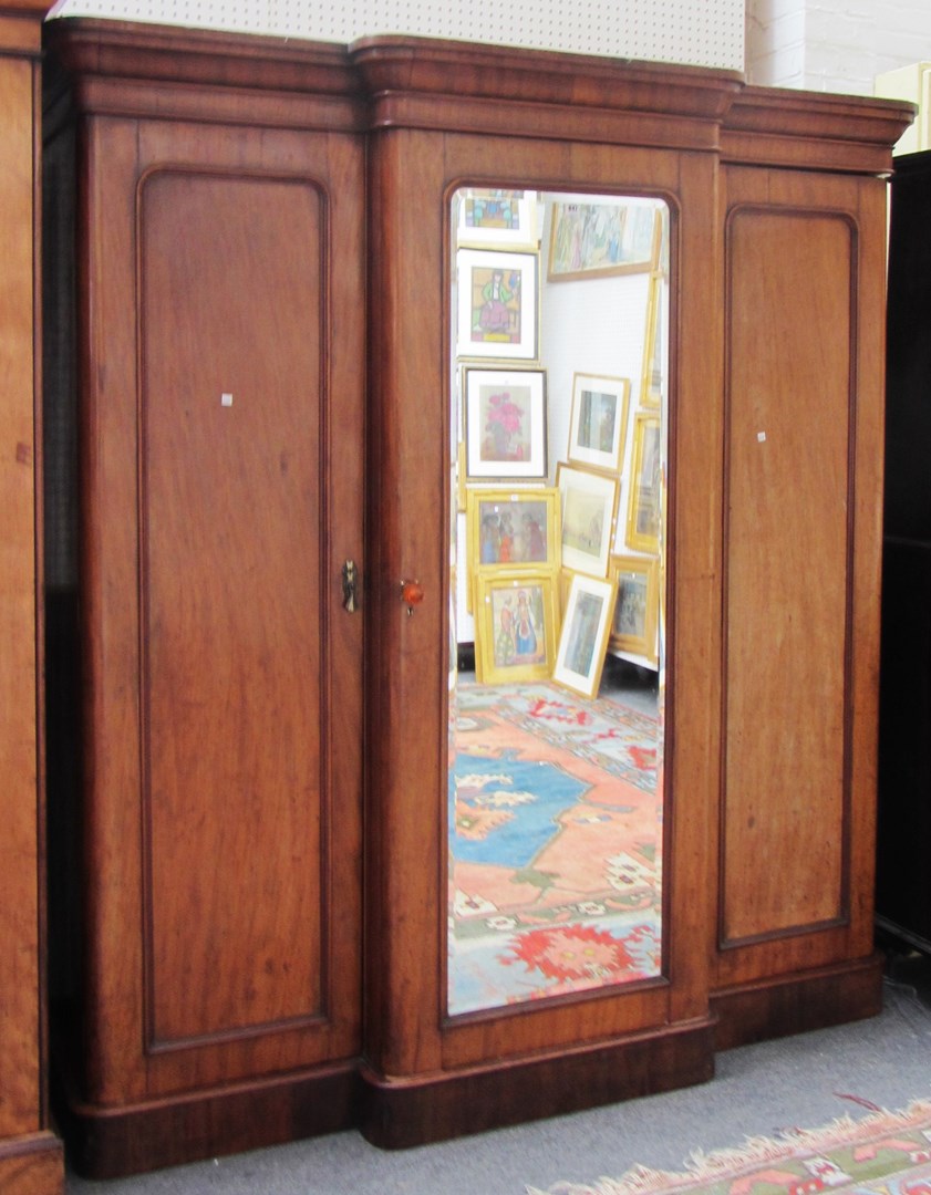 Appraisal: A Victorian mahogany triple wardrobe with central mirror door on