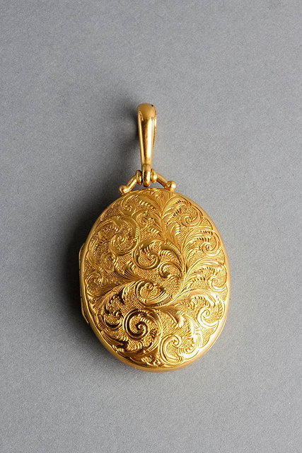 Appraisal: A VICTORIAN OVAL LOCKET with engraved front decorated with leaves