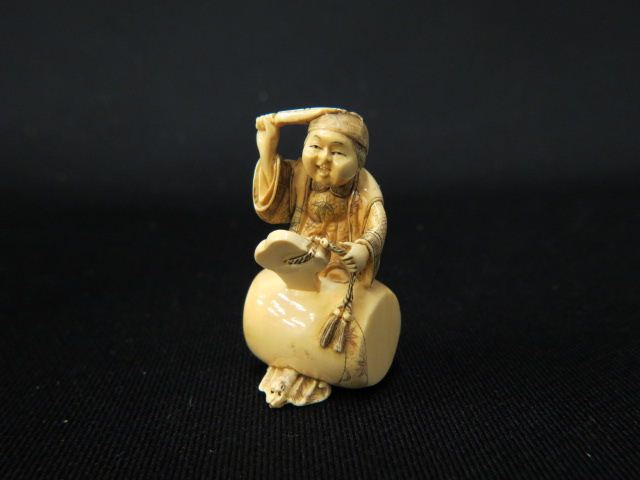 Appraisal: Carved Ivory Netsuke of Boy holding a fan with seated