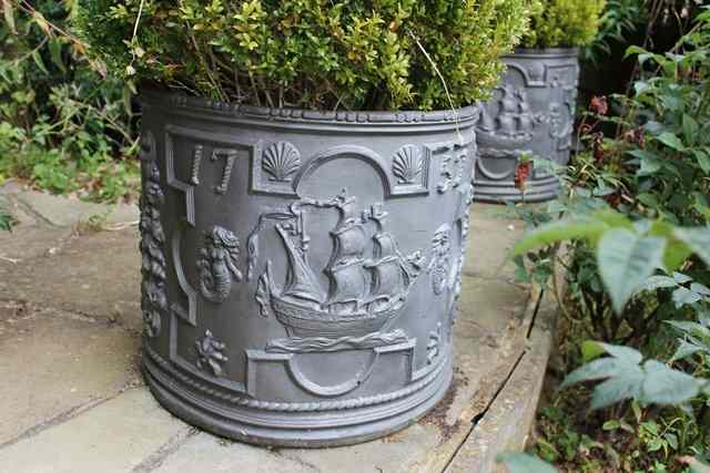 Appraisal: A PAIR OF COMPOSITE CYLINDRICAL PLANTERS decorated with mermaids and