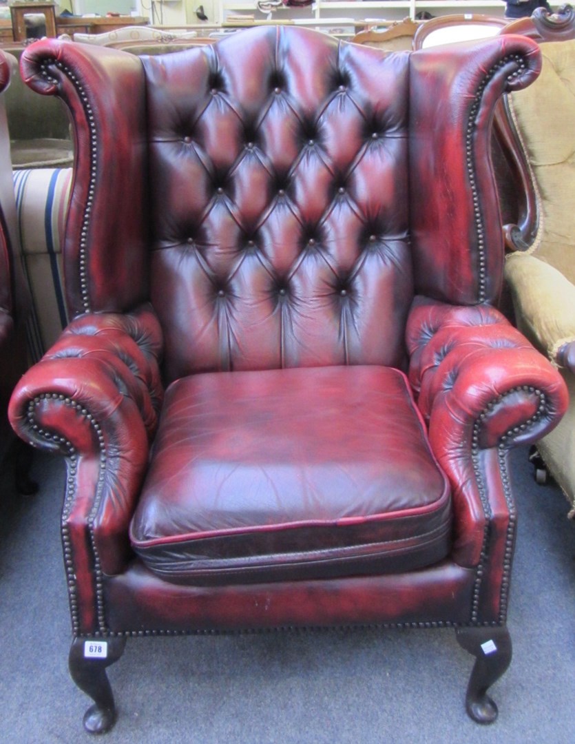 Appraisal: A pair of rouge leather upholstered button back wing armchairs