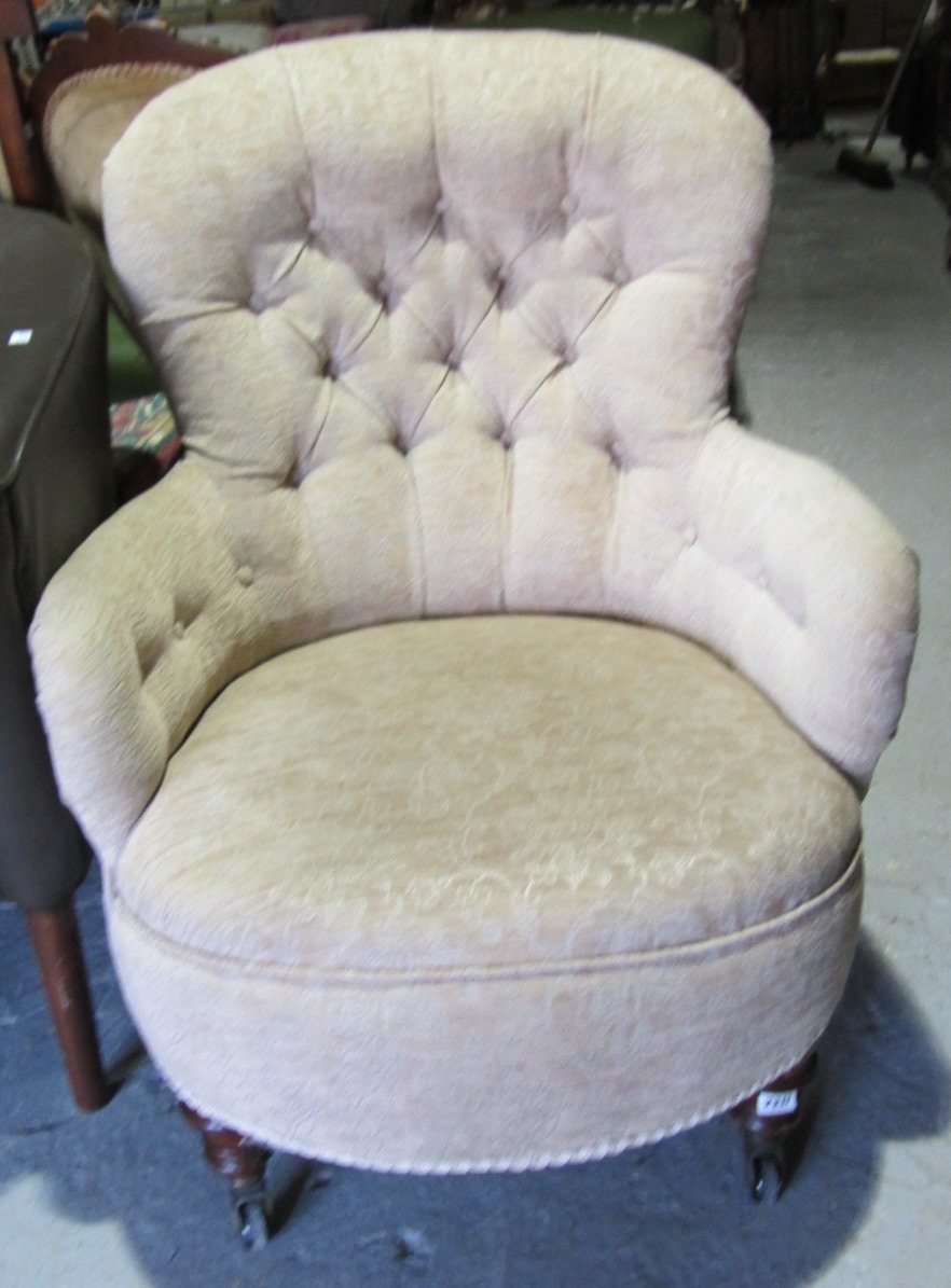 Appraisal: A Victorian button back armchair on turned mahogany supports