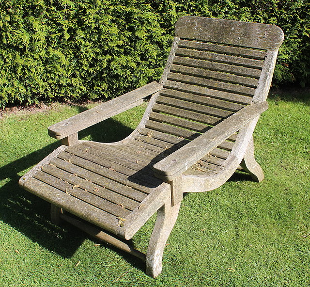 Appraisal: A TEAK PLANTERS CHAIR with horizontal slats and scrolling legs