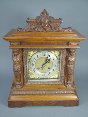 Appraisal: A walnut cased mantel clock of architectural form with caryatid