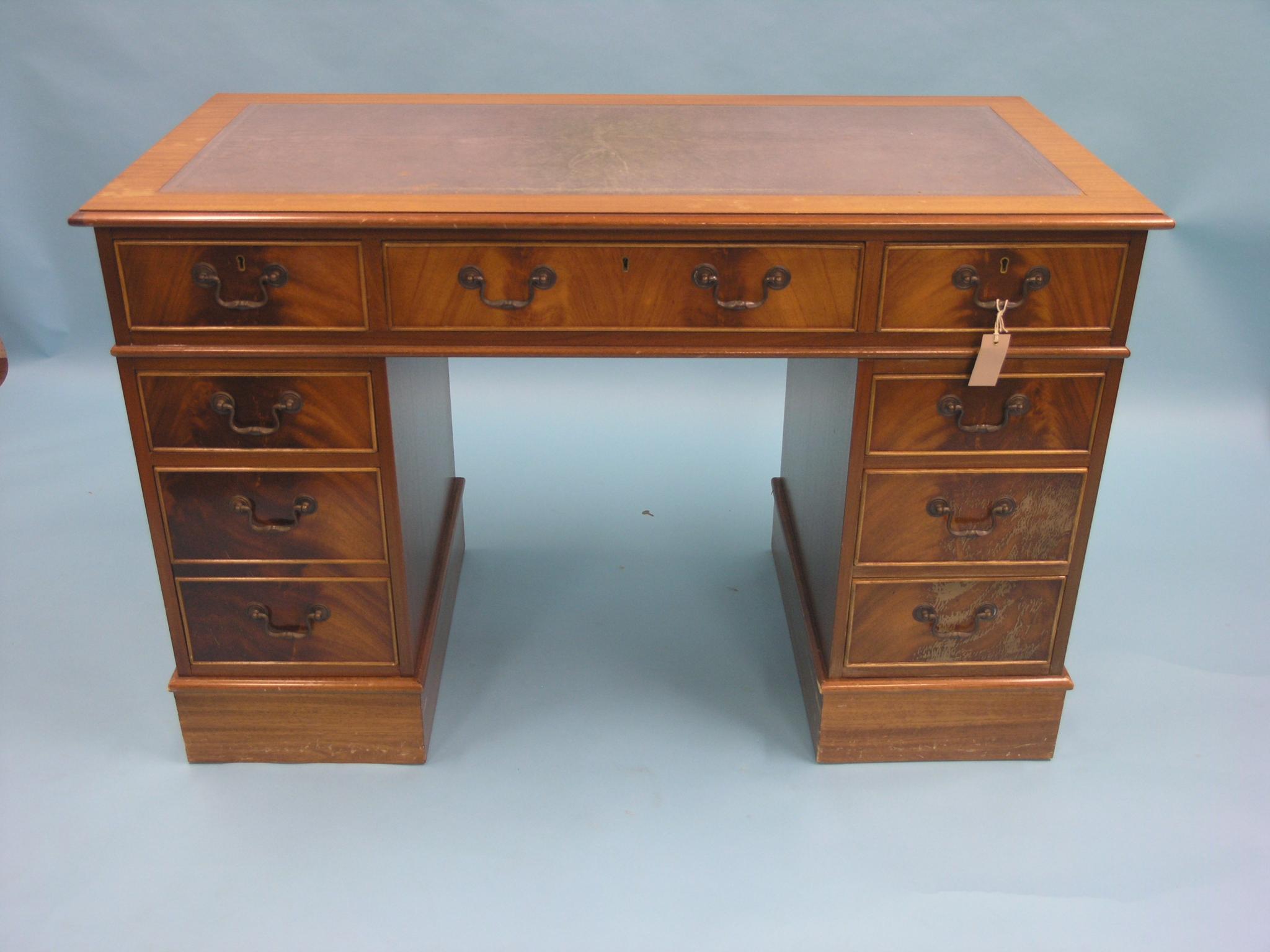 Appraisal: A Georgian-style mahogany desk inset leather top above three frieze