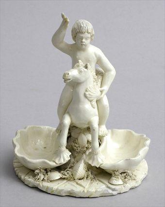 Appraisal: CONTINENTAL FAIENCE FIGURAL SALT Modeled as a boy riding a