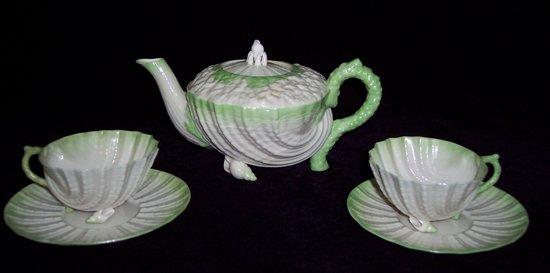 Appraisal: A Belleek teapot and cover of shell form encrusted with