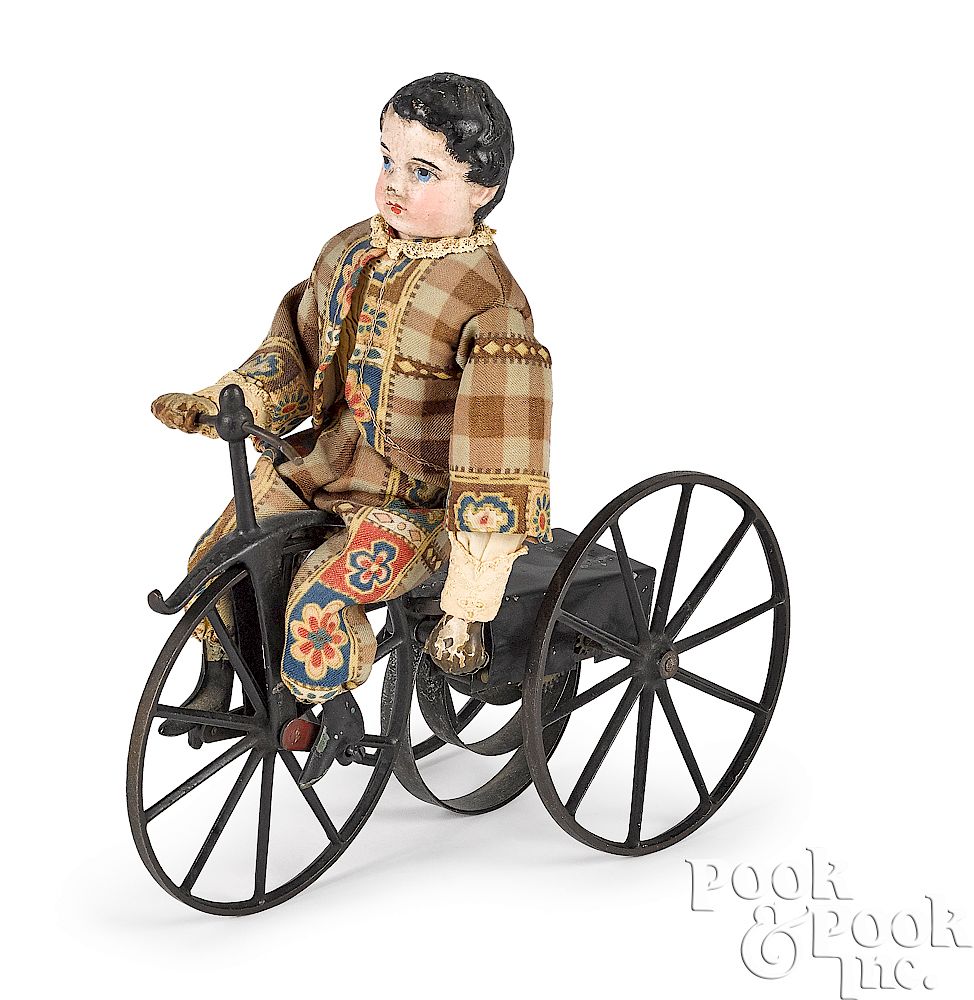 Appraisal: Composition boy riding clockwork velocipede Composition boy riding an iron