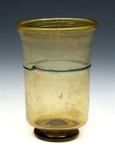 Appraisal: A ROMAN AMBER GLASS FOOTED BEAKER decorated with horizontal blue