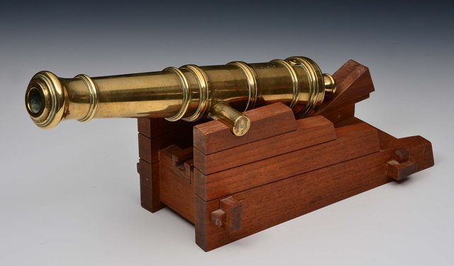 Appraisal: A LARGE TABLE TOP BRASS CANNON supported by a wooden