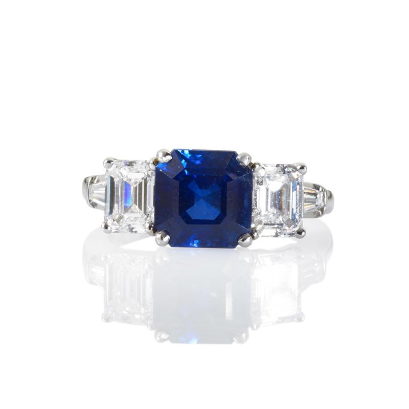 Appraisal: SAPPHIRE AND DIAMOND THREE-STONE RING Square step cut blue sapphire