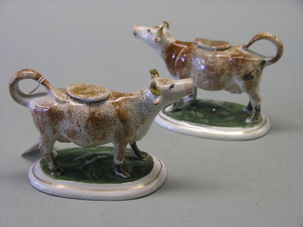 Appraisal: A pair of early Victorian Staffordshire pottery cow creamers painted