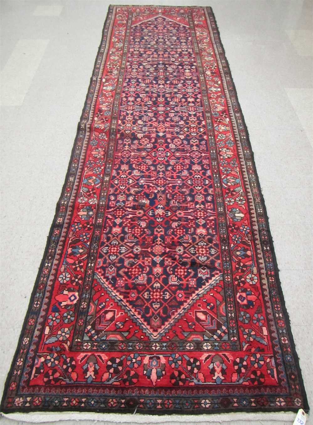 Appraisal: PERSIAN HALL RUG featuring an overall Herati floral motif on