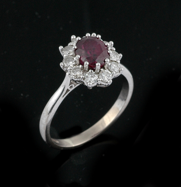 Appraisal: A ruby and diamond cluster ring The oval ruby weighing