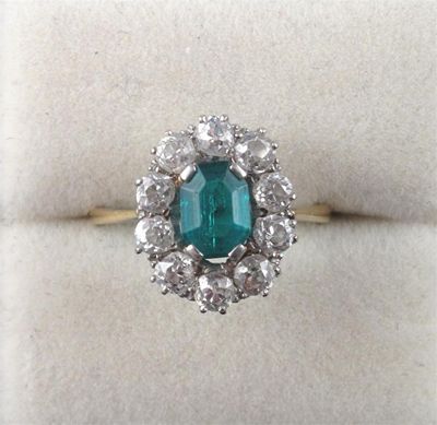 Appraisal: An emerald and diamond cluster ring The octagonal cut emerald