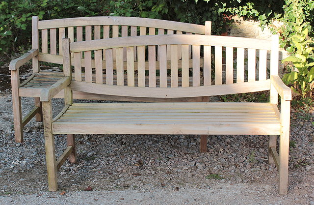 Appraisal: A PAIR OF TEAK GARDEN BENCHES with shaped backs slatted