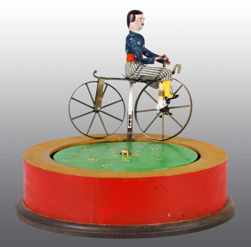 Appraisal: Composition Bicyclist Toy Riding on Round Base Description Mechanical toy