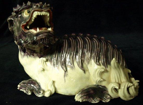 Appraisal: A Chinese figure of a dog of Fo his head